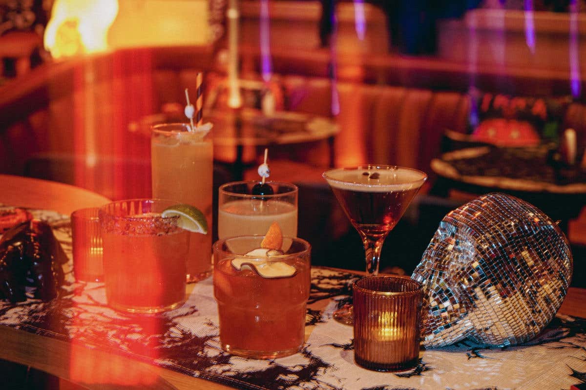 Assortment of Halloween-themed cocktails displayed on a table with festive décor.