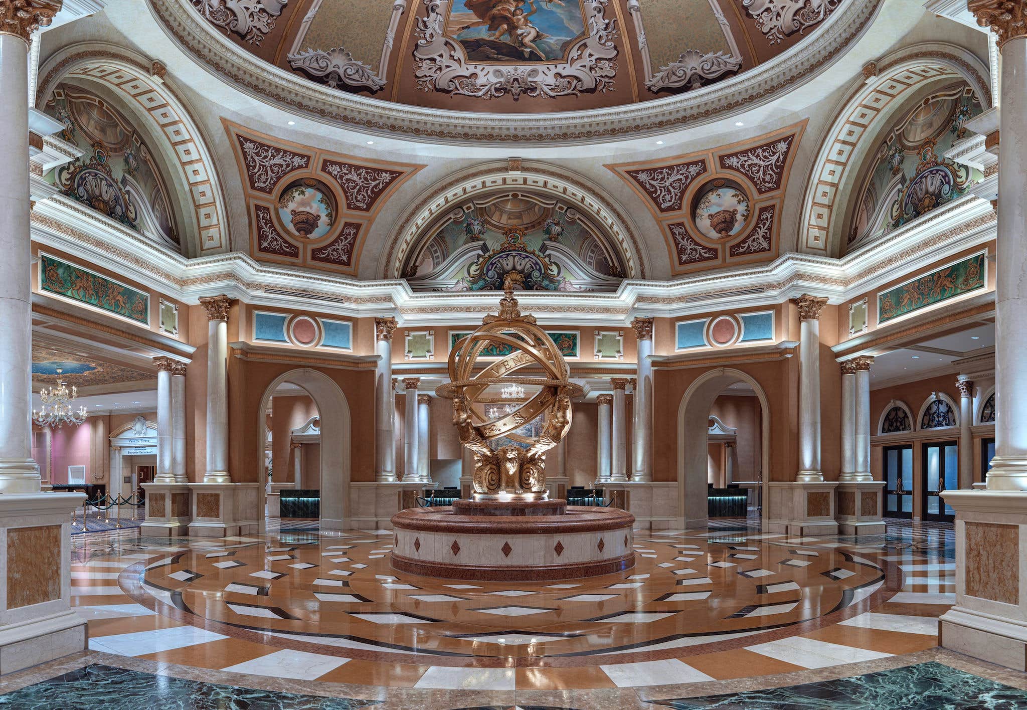 A luxurious, ornate interior with a central golden armillary sphere, surrounded by arches, intricate ceilings, and marble floors.