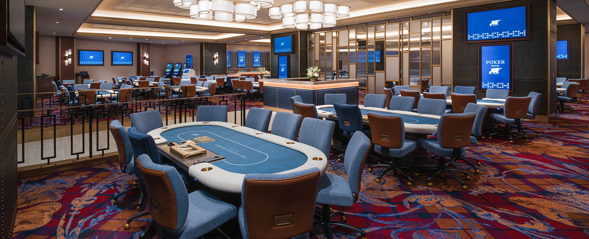 A large open room with multple blue poker tables