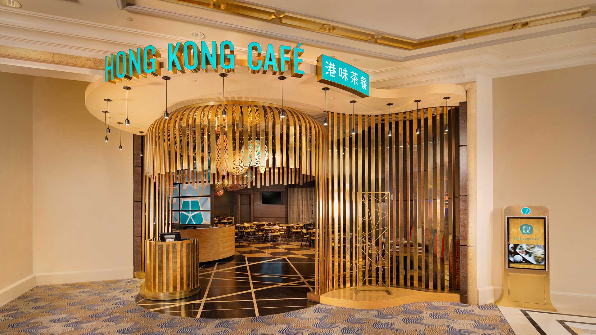 Entrance of the Hong Kong Café with modern, stylish decor including wooden slats and neon signage in a spacious, well-lit area.