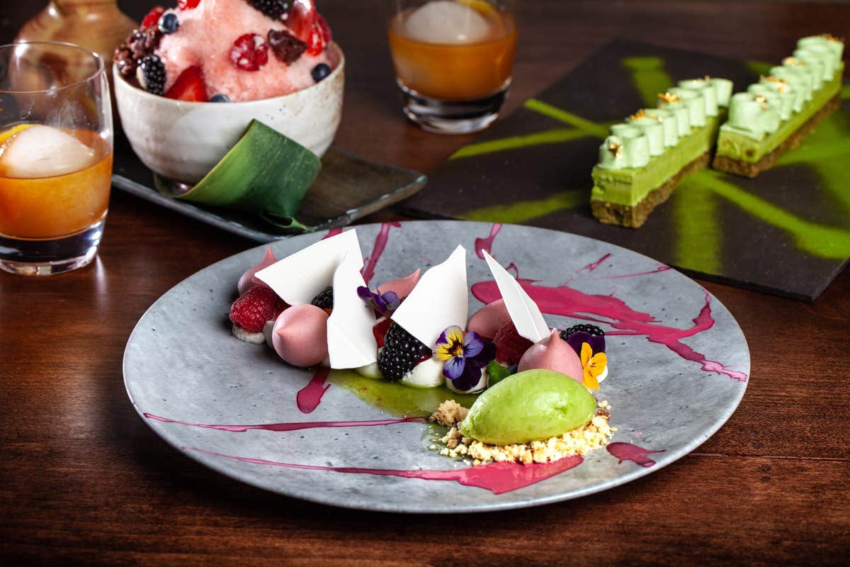 A gourmet dessert spread with a variety of colorful sweets and artistic presentation on a wooden table.