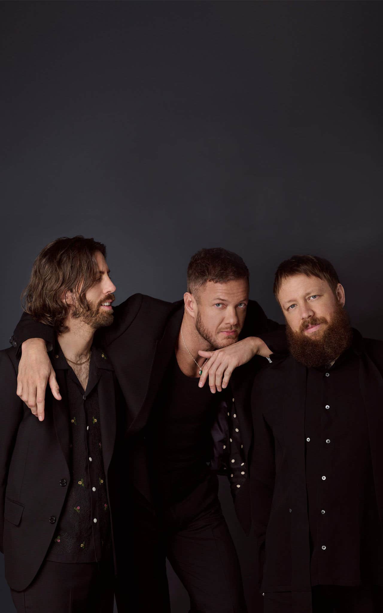 Imagine Dragons band members in dark jackets and shirts.