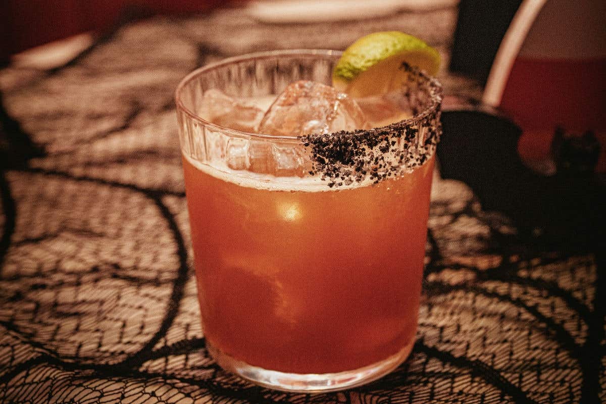 Halloween-themed margarita with a lime garnish.