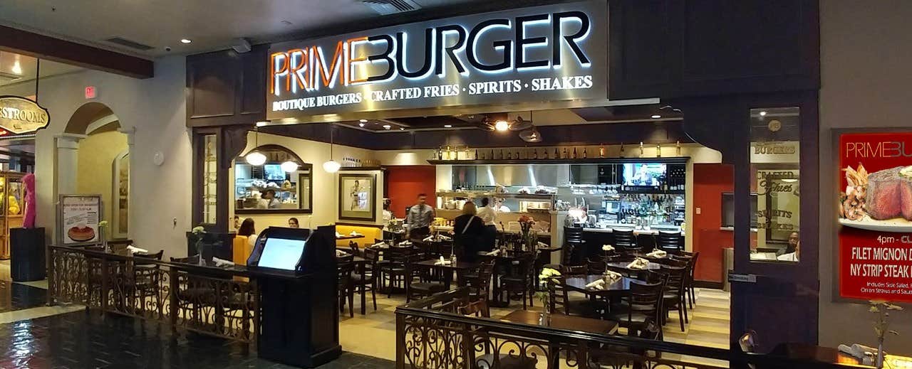 A restaurant named "Prime Burger" with seating area and visible kitchen, offering crafted fries, spirits, and shakes.