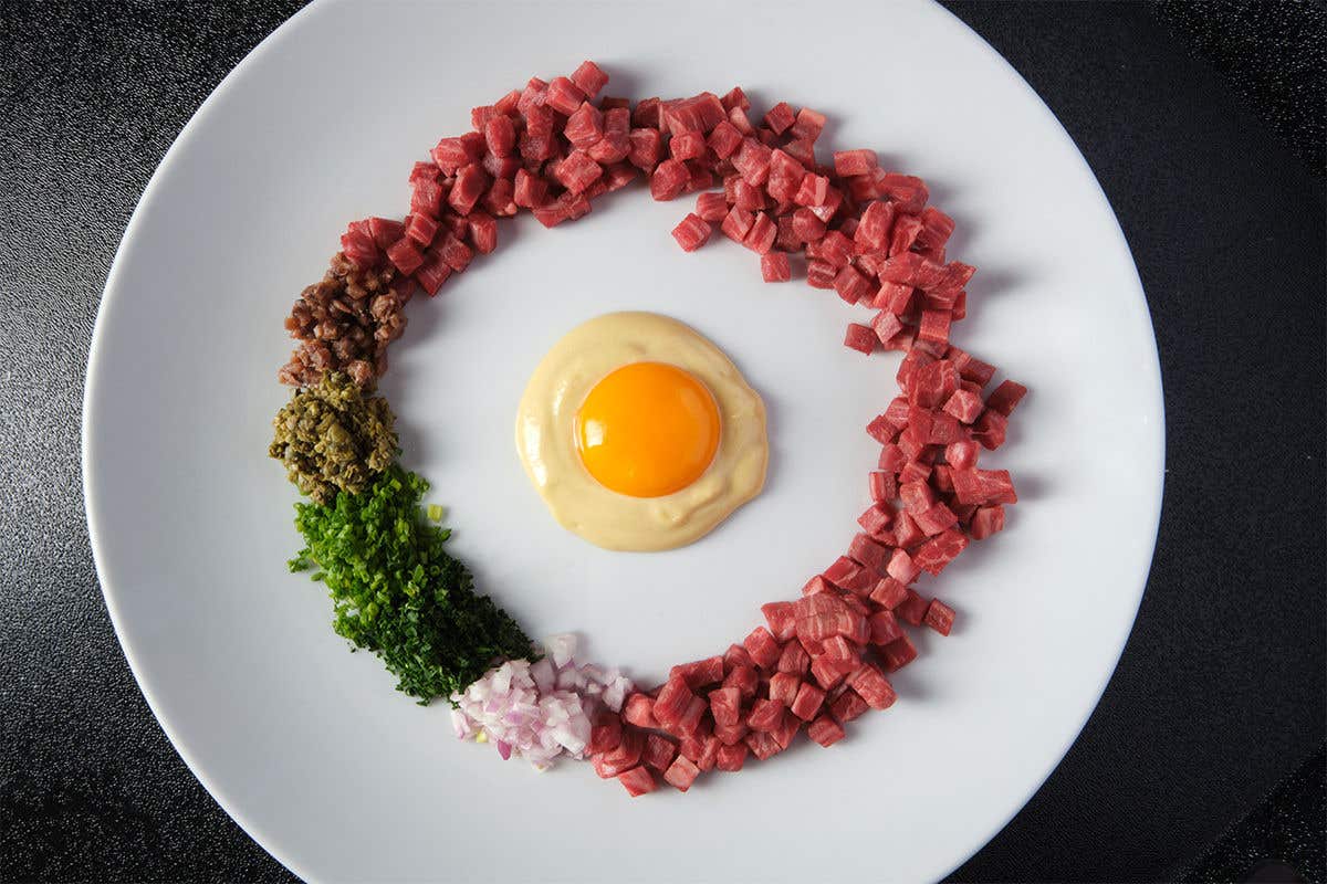 Chopped meat, scallions, onions, and seasoning circled around a over easy egg. 