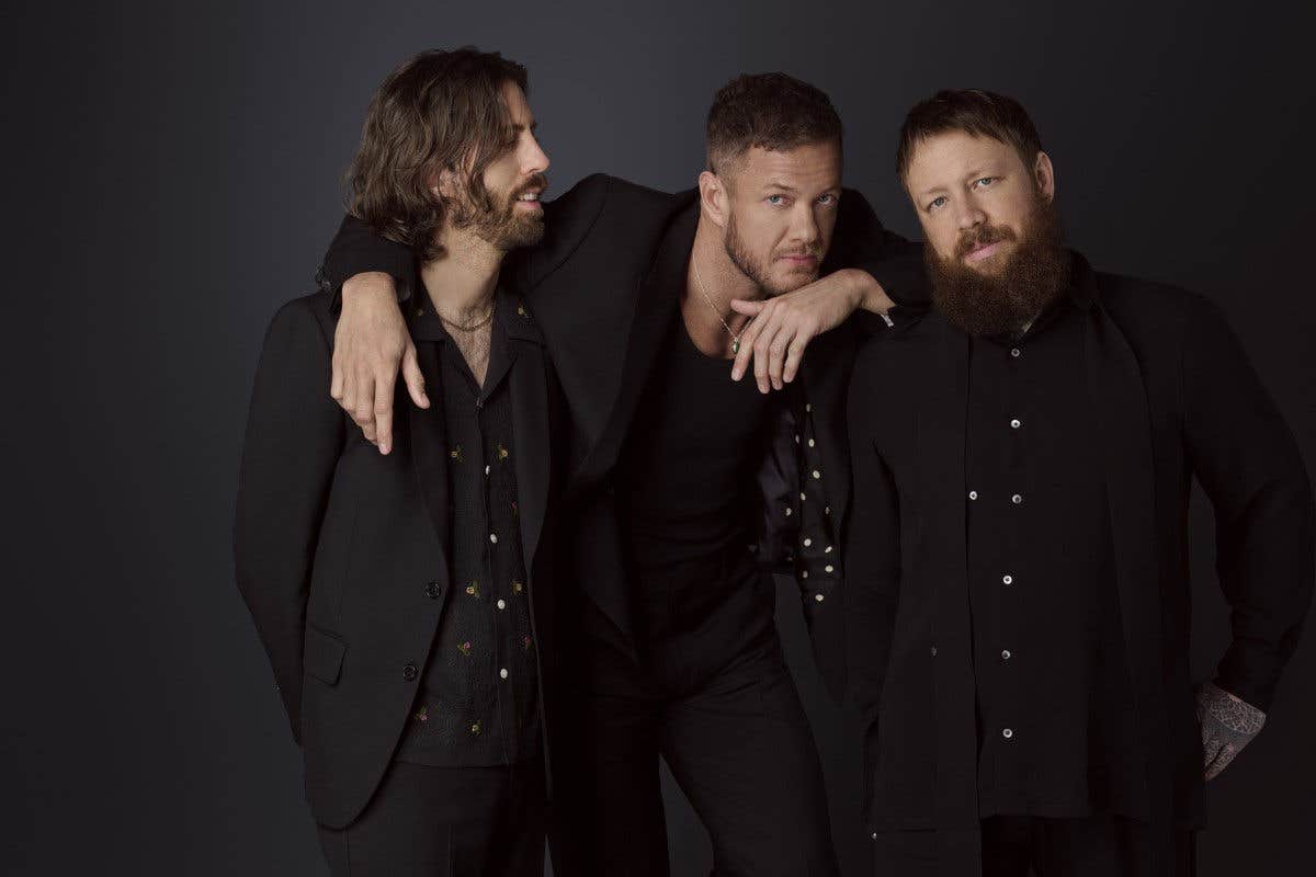 Imagine Dragons band members in dark jackets and shirts.