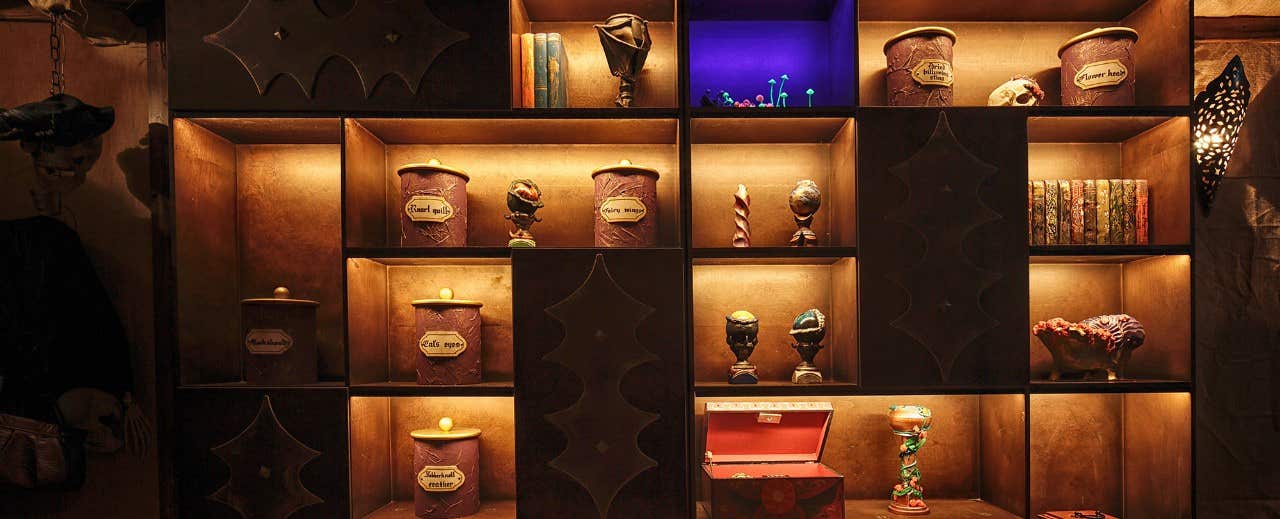 A dimly lit shelf showcasing various jars, books, and decorative items in a mystical, antique style.