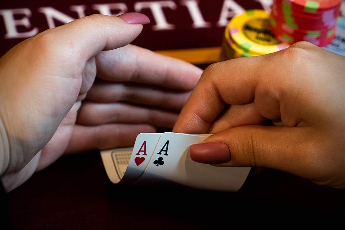 A person checking their pair of Aces in hand