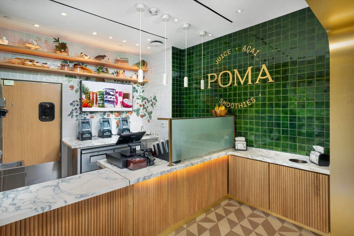 Interior view of POMA juice and smoothie bar with green tile wall.