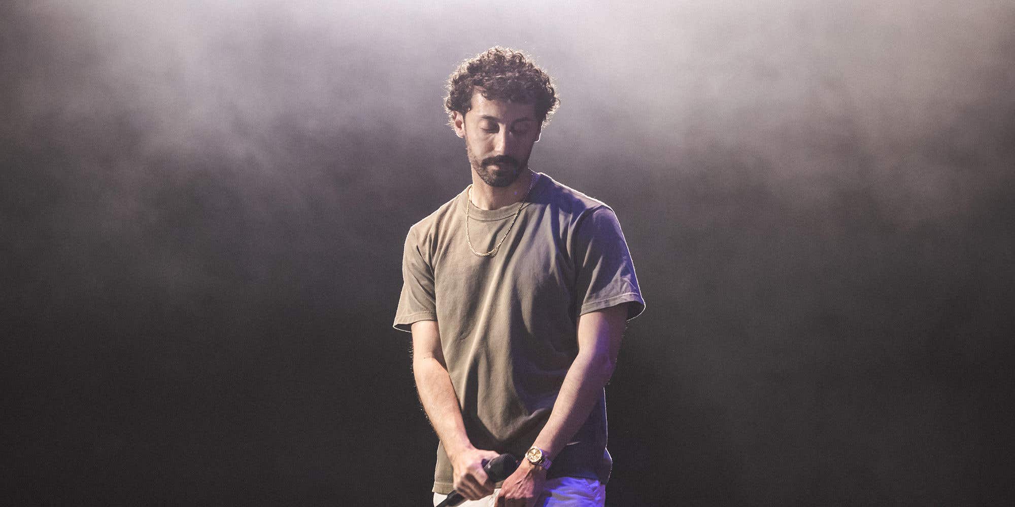 Comedian Morgan Jay on a smoky stage holding a microphone.