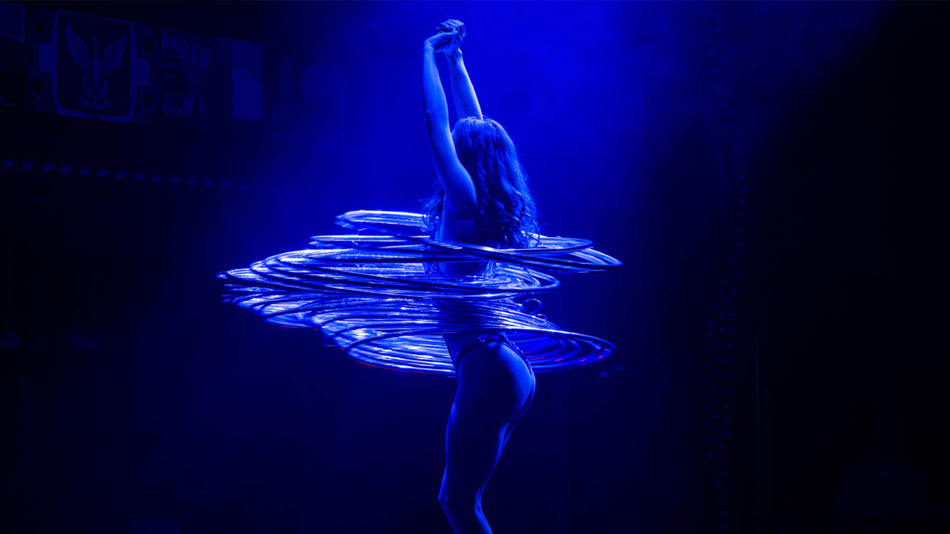 Talent with multiple hoops around her waist dancing on stage.