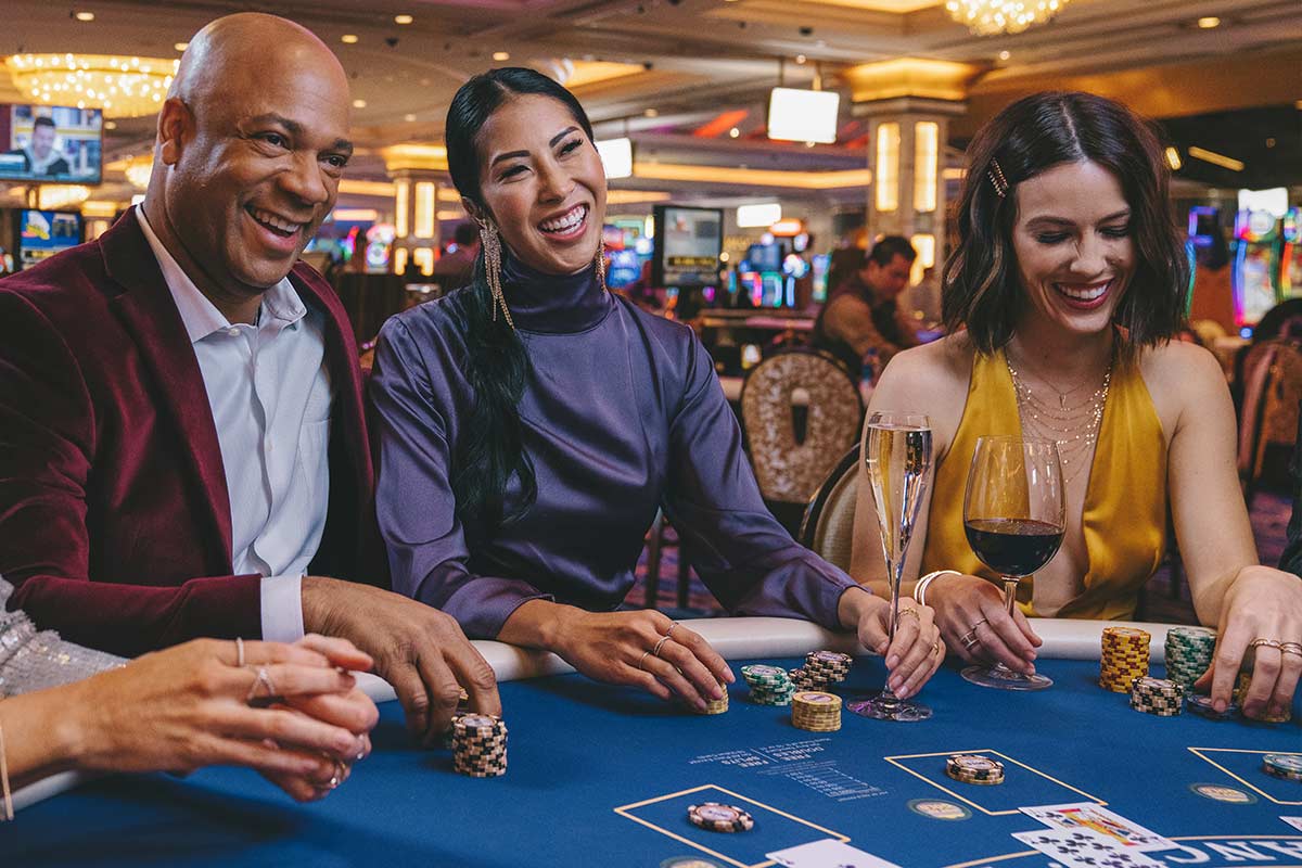 A group of smiling people gathered around a poker table